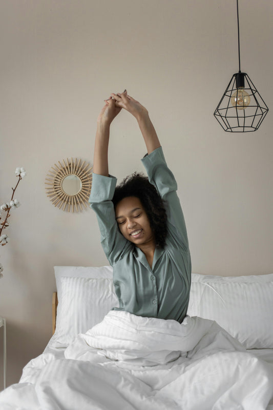 Mujer estirándose en la cama por la mañana