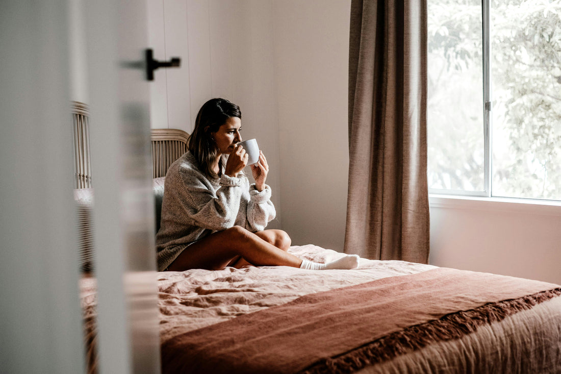 Mujer junto a una ventana, disfrutando del silencio.